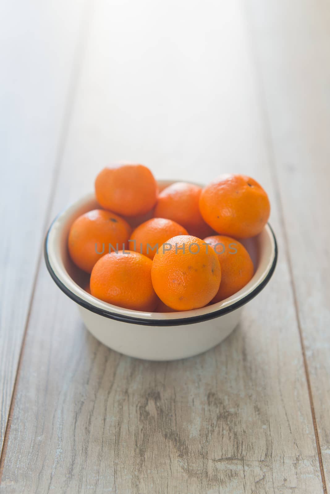 Plate with tangerines on the wood background