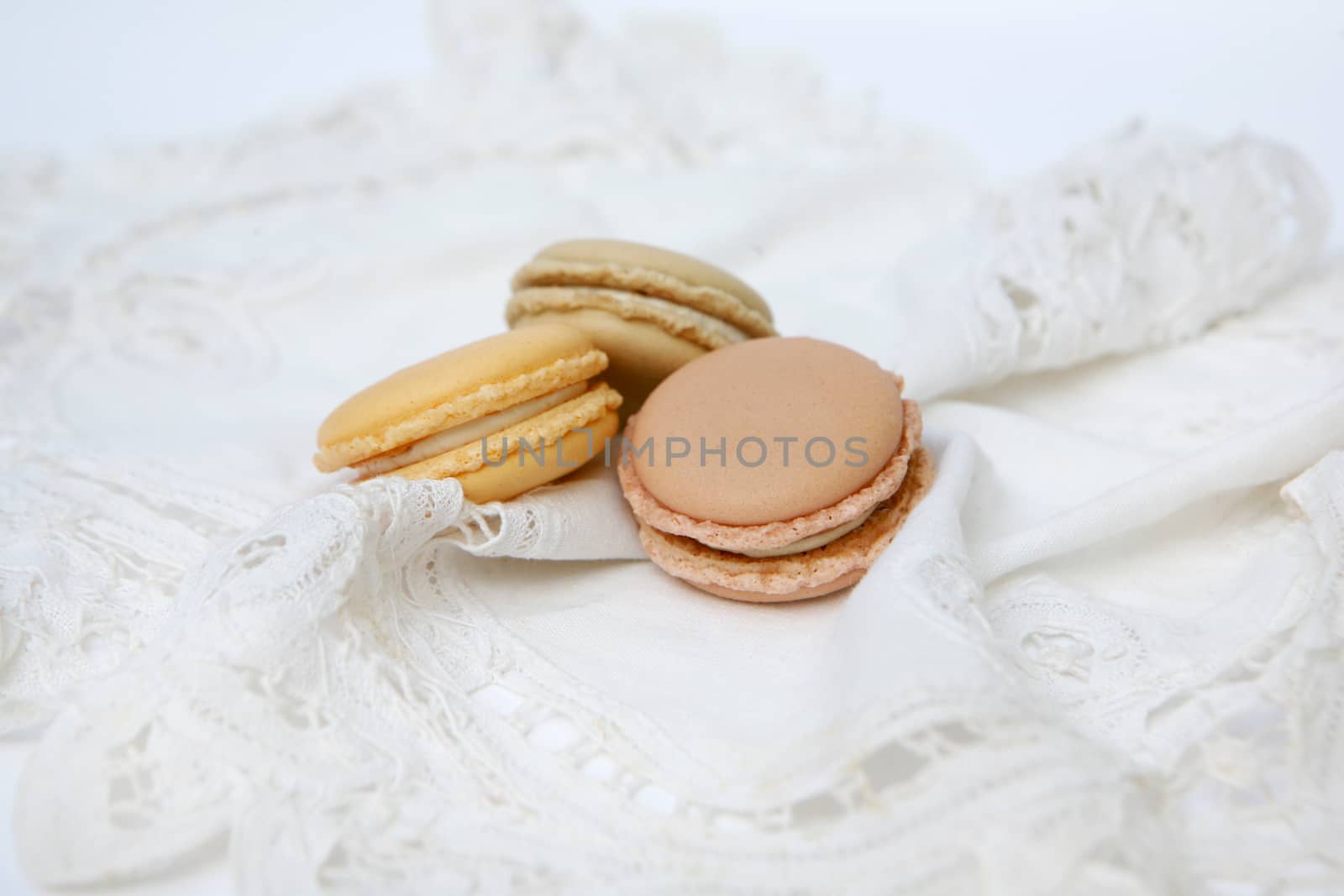 French colorful macaroons isolated on lace white by ohhlanla