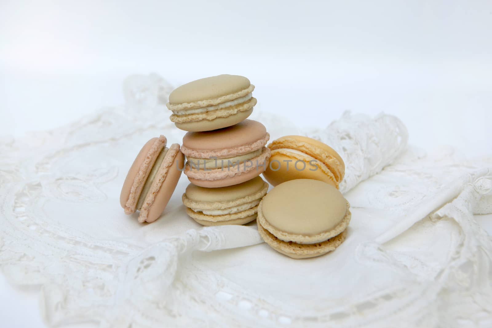 French colorful macaroons isolated on lace white by ohhlanla