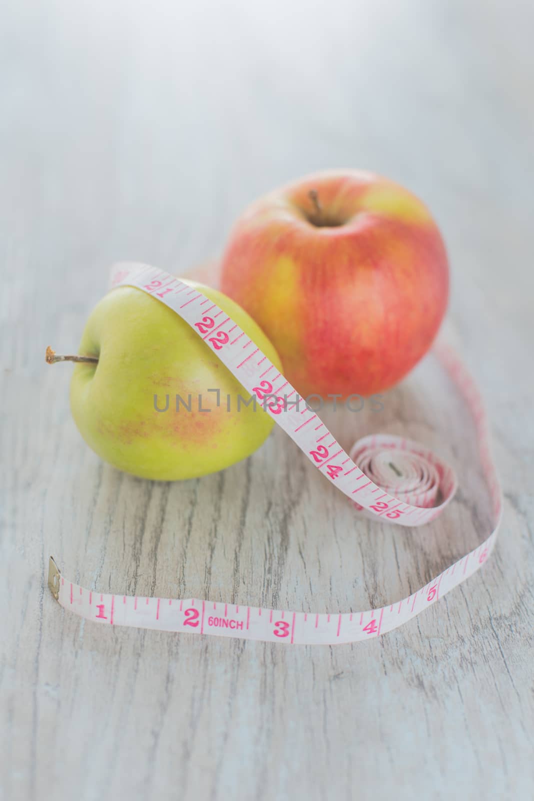 Apples in the measuring tape on the wood background