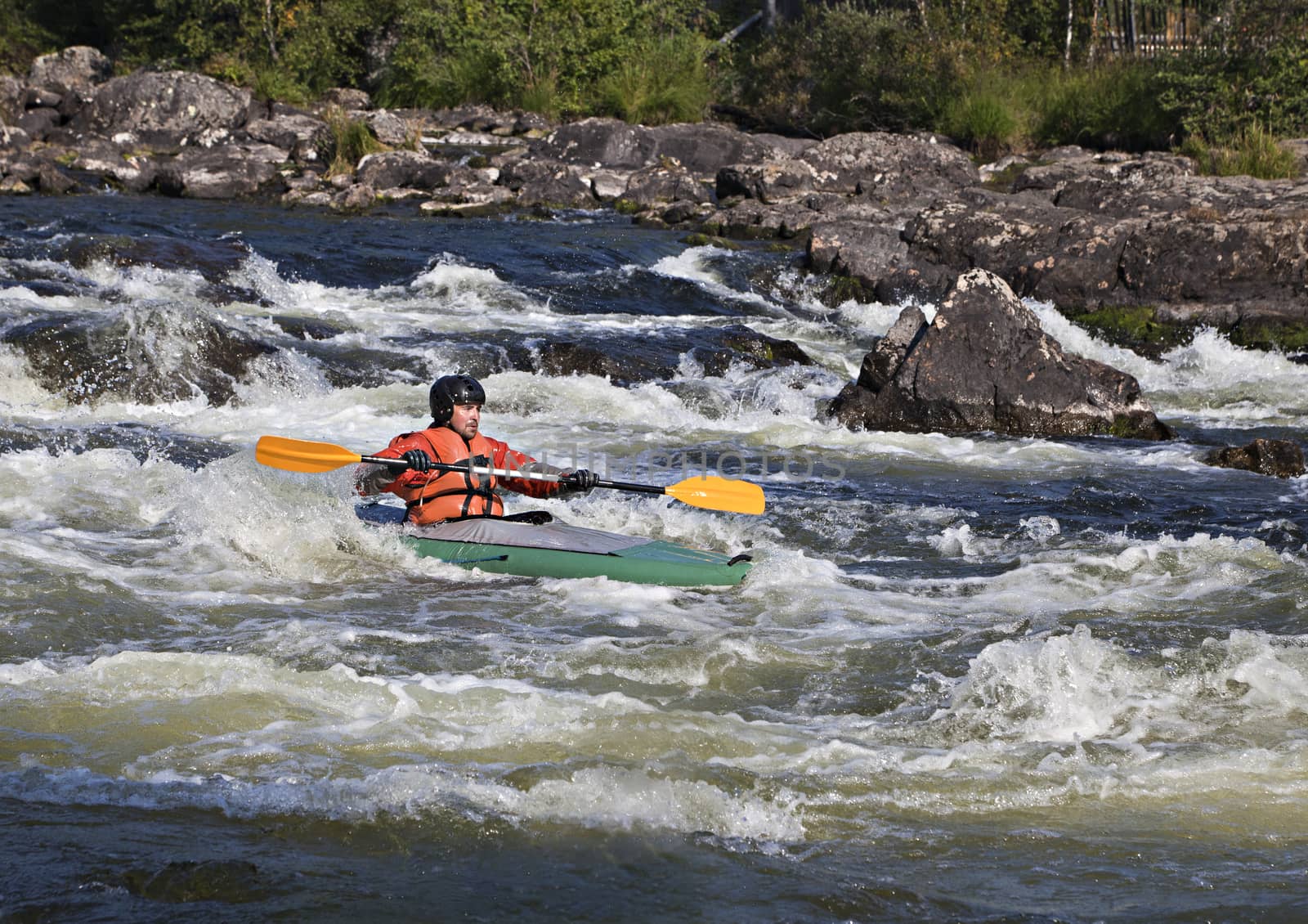 Kayaker in the  whitewater of a river Umba in Russia