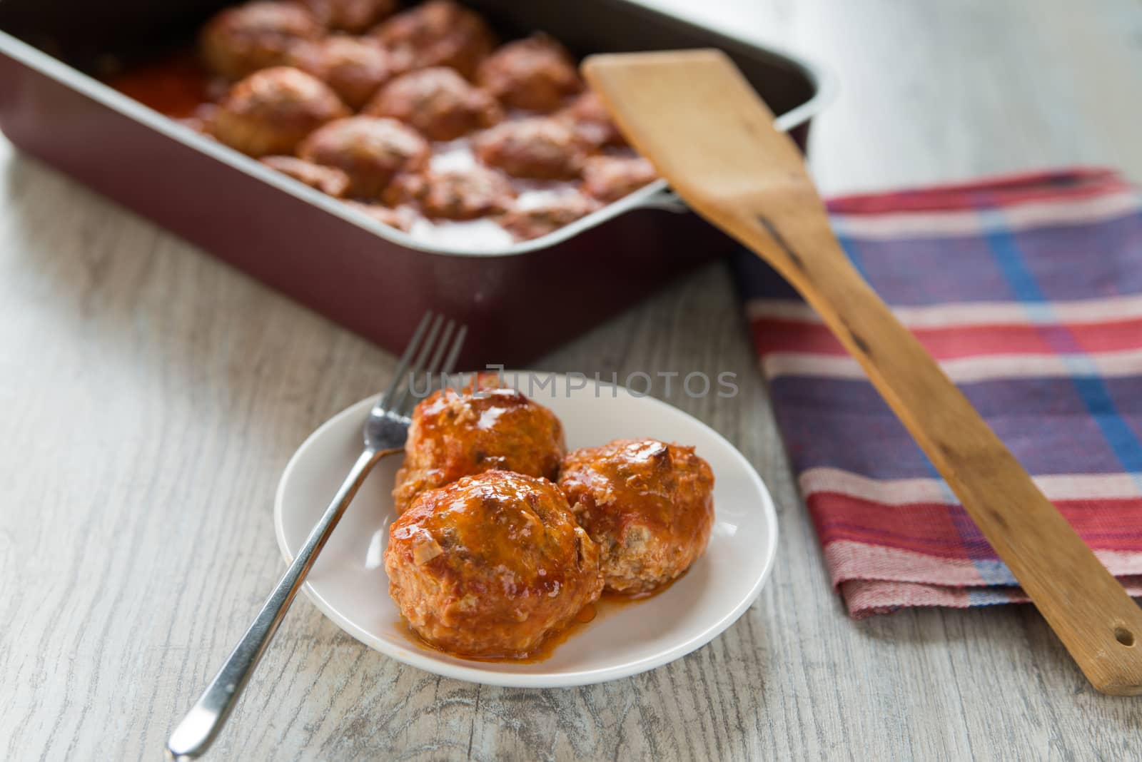 Portion of three meatballs on white plate