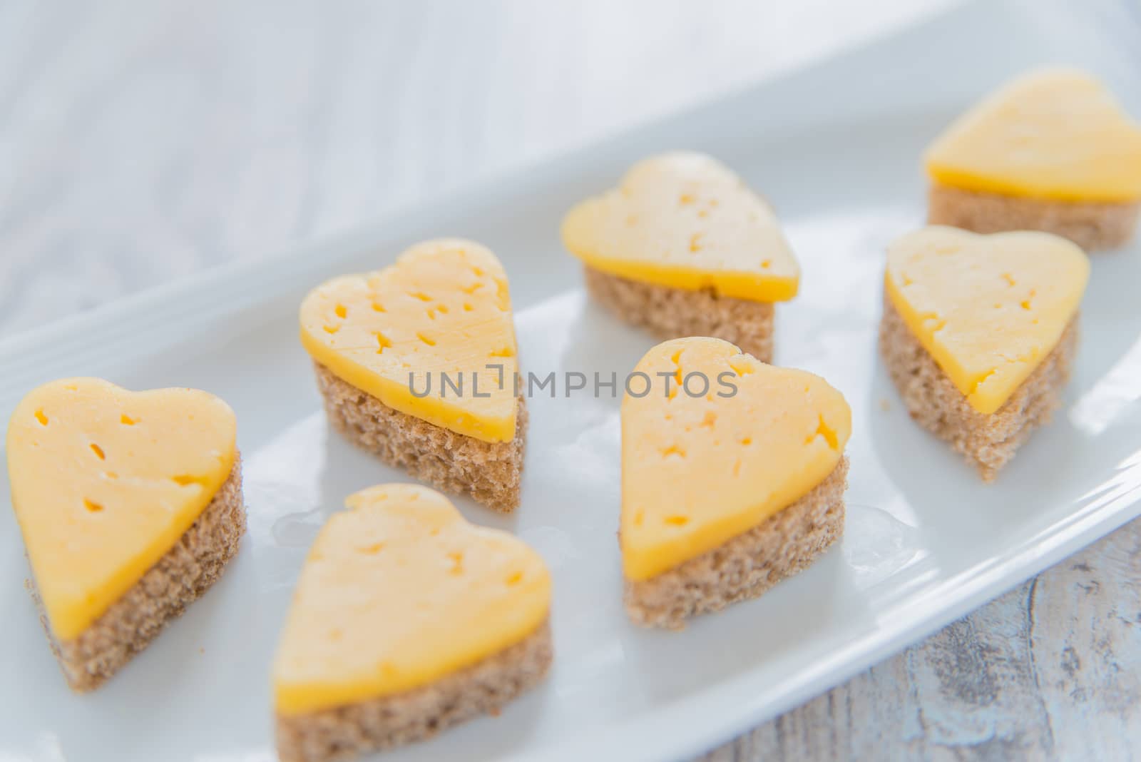 Heart shaped cheese sandwiches on the white plate