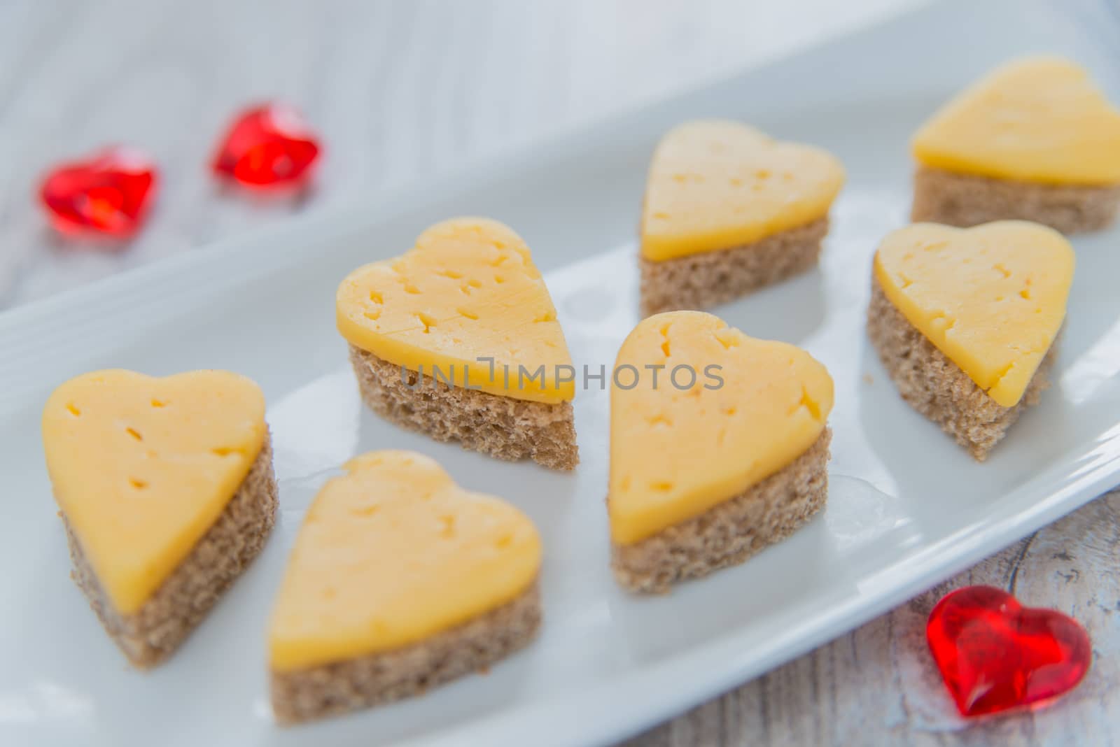 Heart shaped cheese sandwiches on the white plate