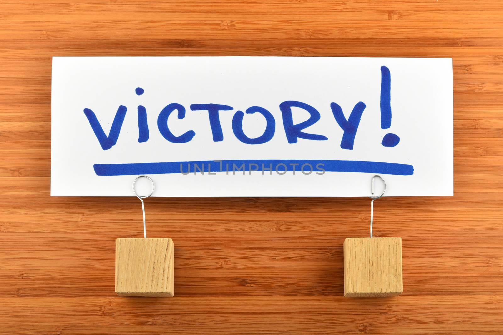 Victory paper note with  holders on wooden background by BreakingTheWalls