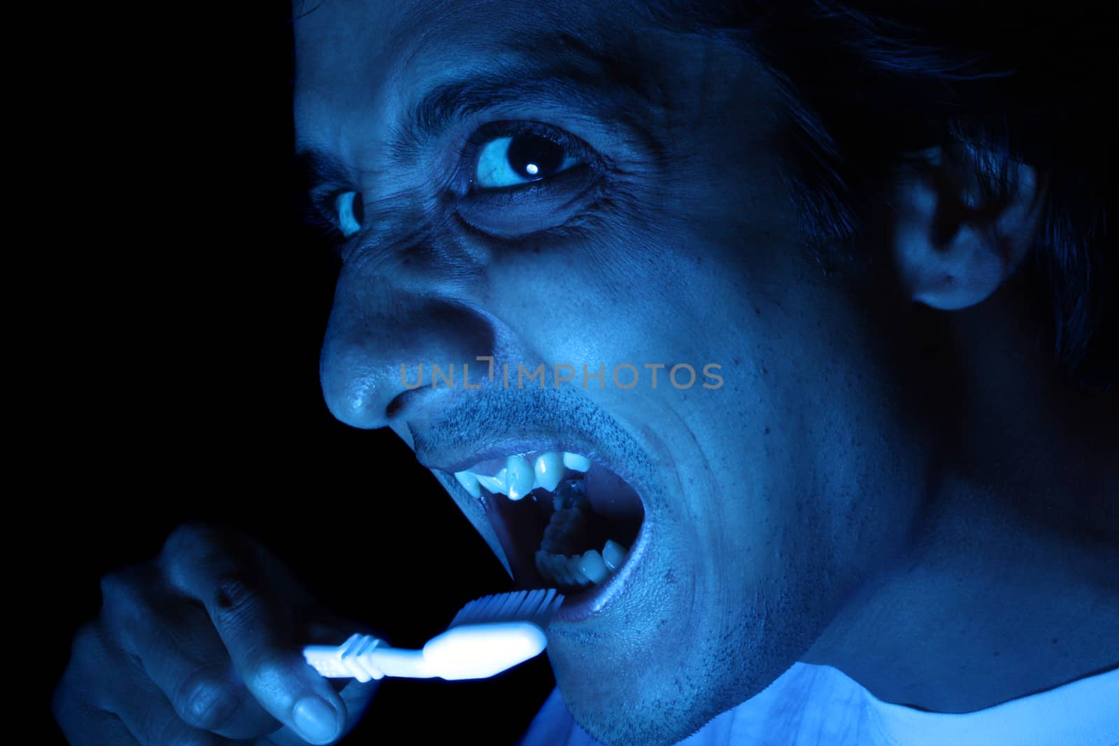 A funny image showing an Indian man brushing his teeth in the night.