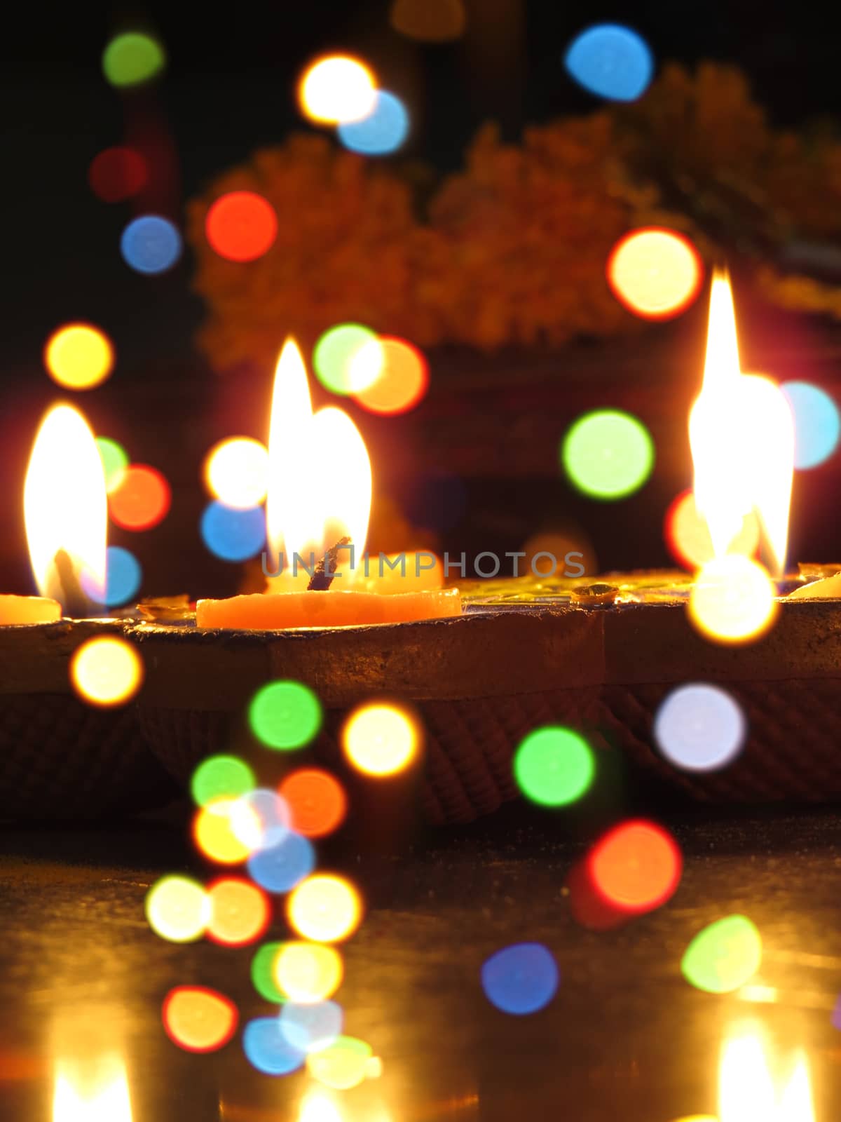 A view of traditional Diwali earthen lamps through colorful blur lights.