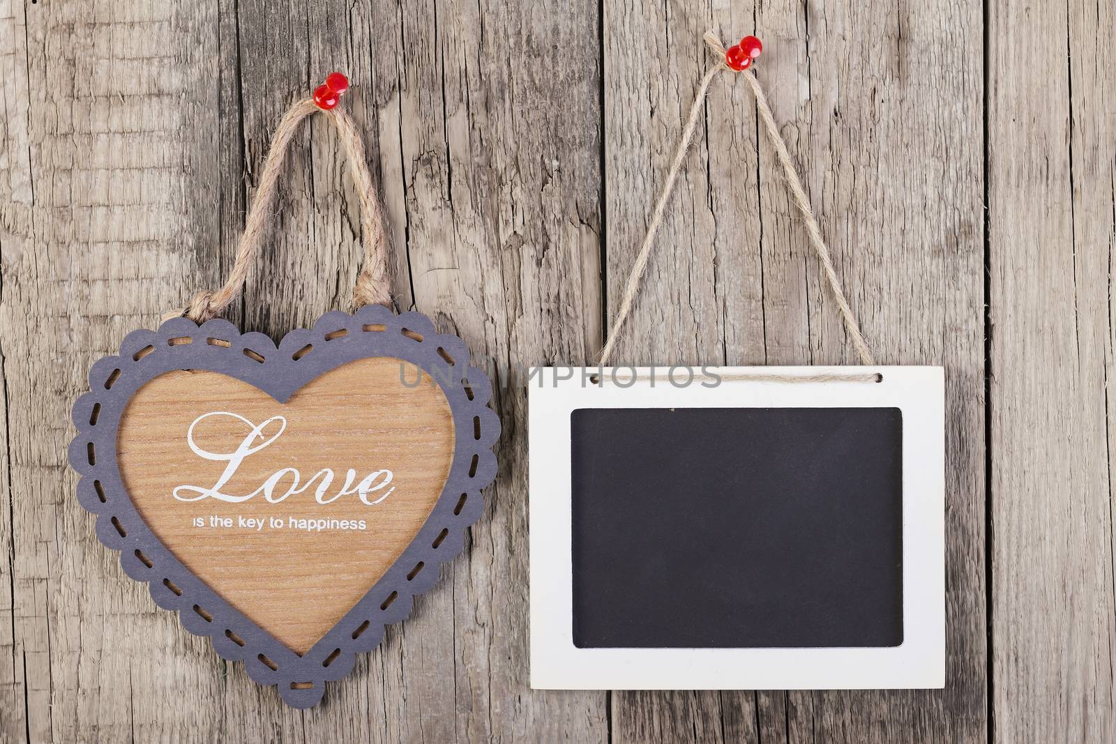 Empty wooden blackboard sign and heart shape frame whith love text on wooden background