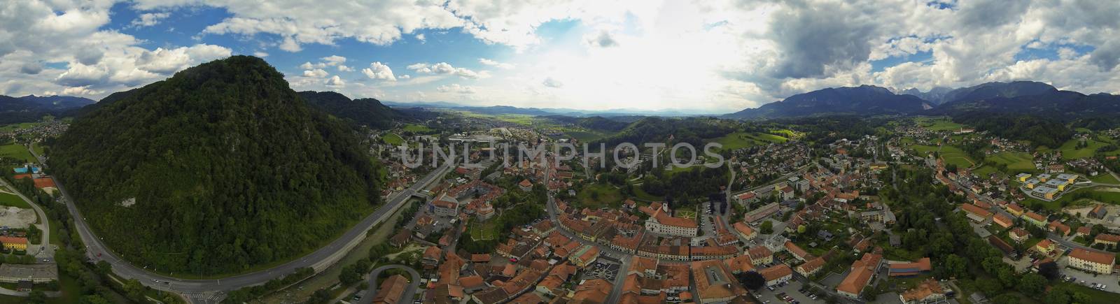 Aerial panorama of suburban town Kamnik in Slovenia, with "stari grad" on the left and city in the middle.