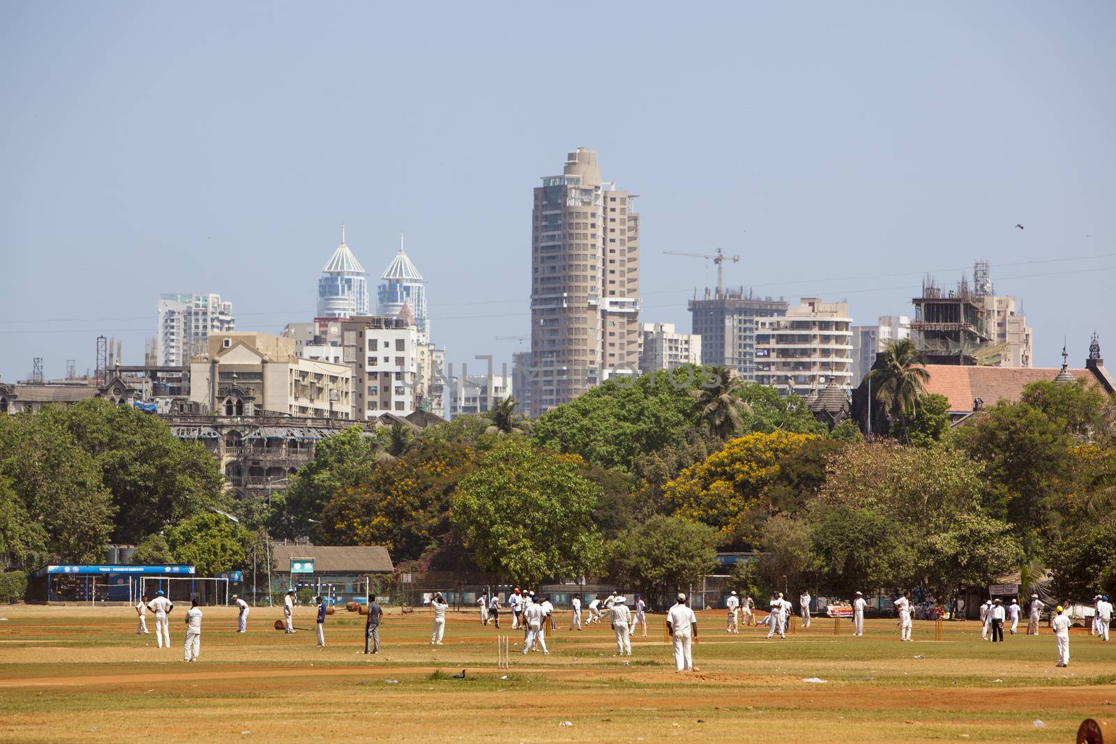 Mumbai, India - April 16, 2013: Indians playing cricked on a field in the centre of Mumbai.
