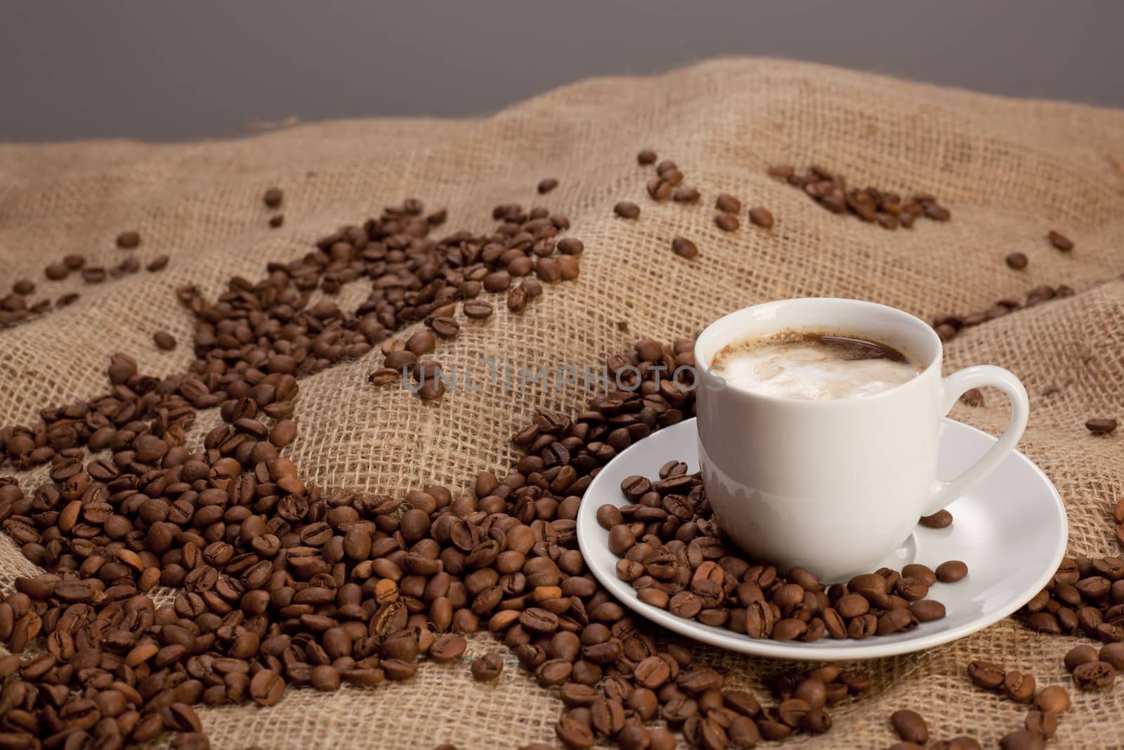 Cup of coffee on a sack with beans