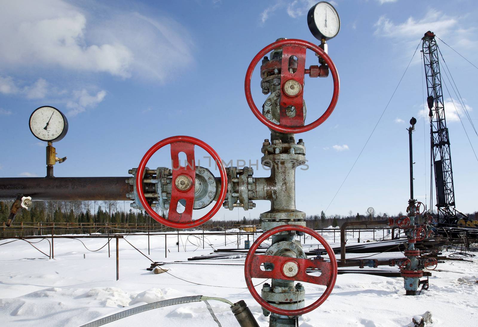 Steel pipeline with red valves against blue sky