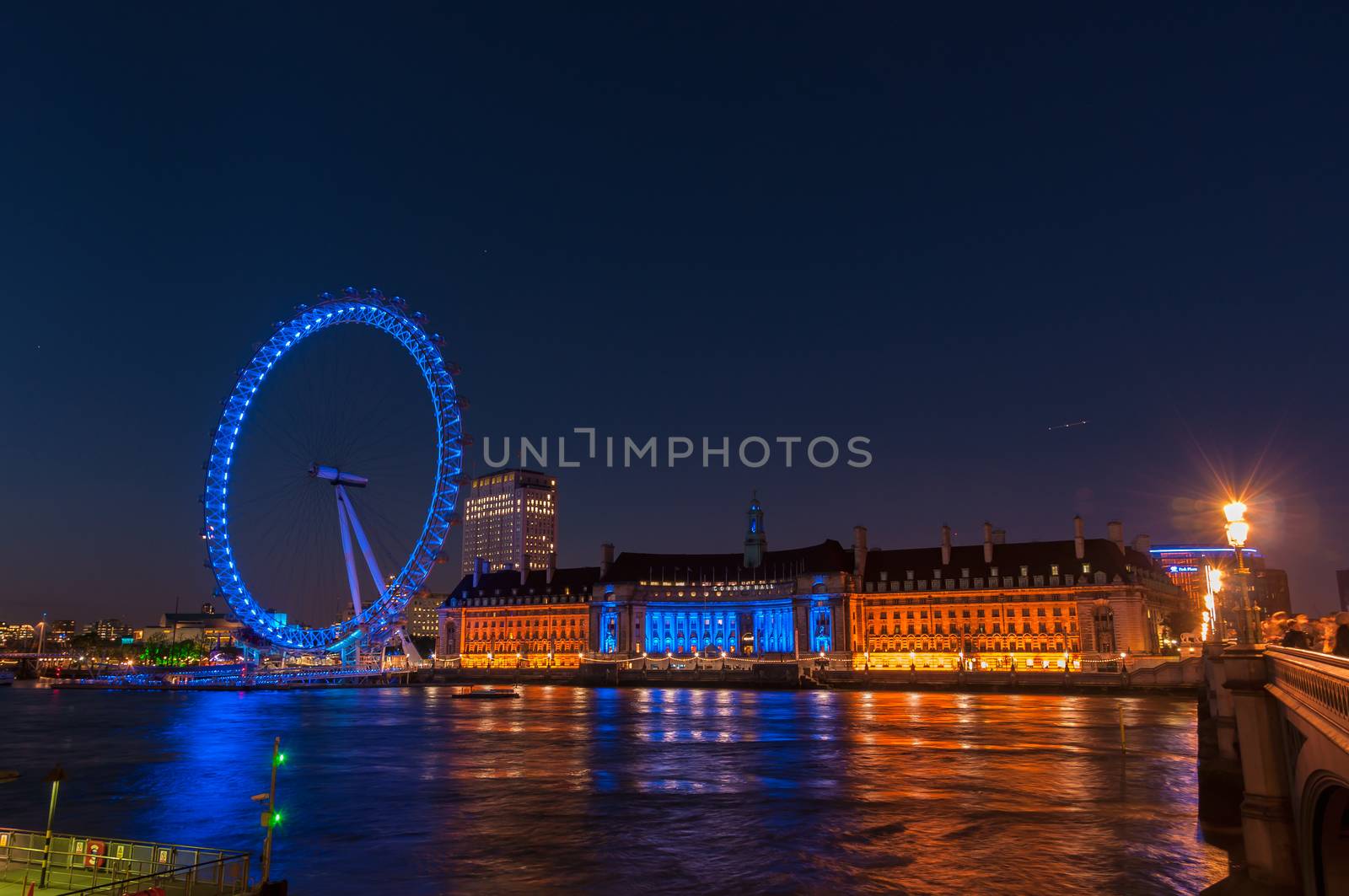 London, United Kingdom - May 10, 2011: Night view of the South Bank of the River Thames including the world famous landmark, London Eye.