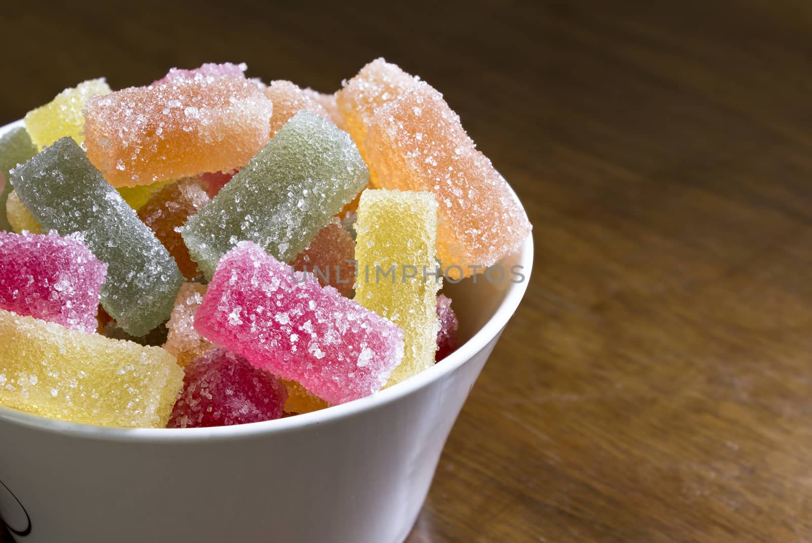 Jelly sweets in a bowl on a wooden table
