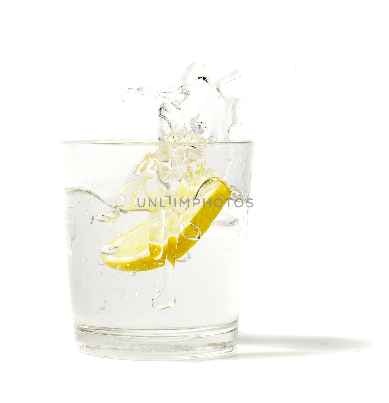 lemon splashing in glass on a white background