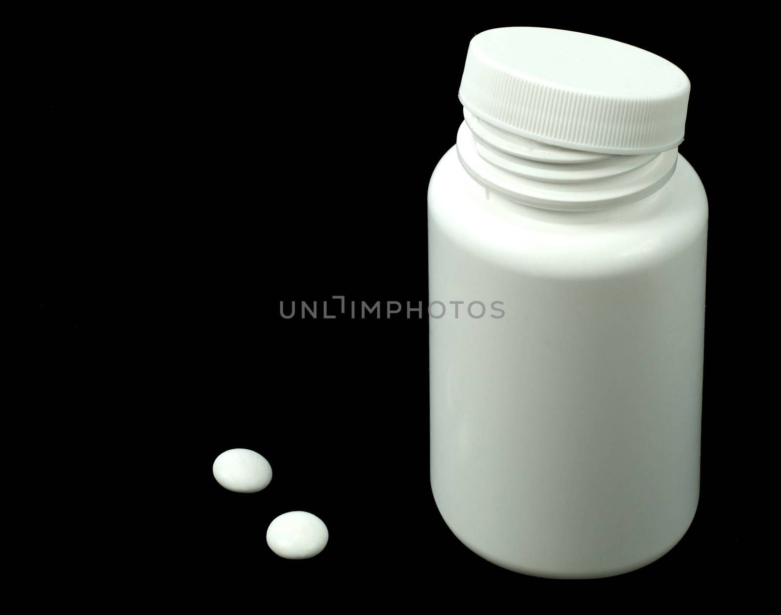 two white pills with white jar on a black background