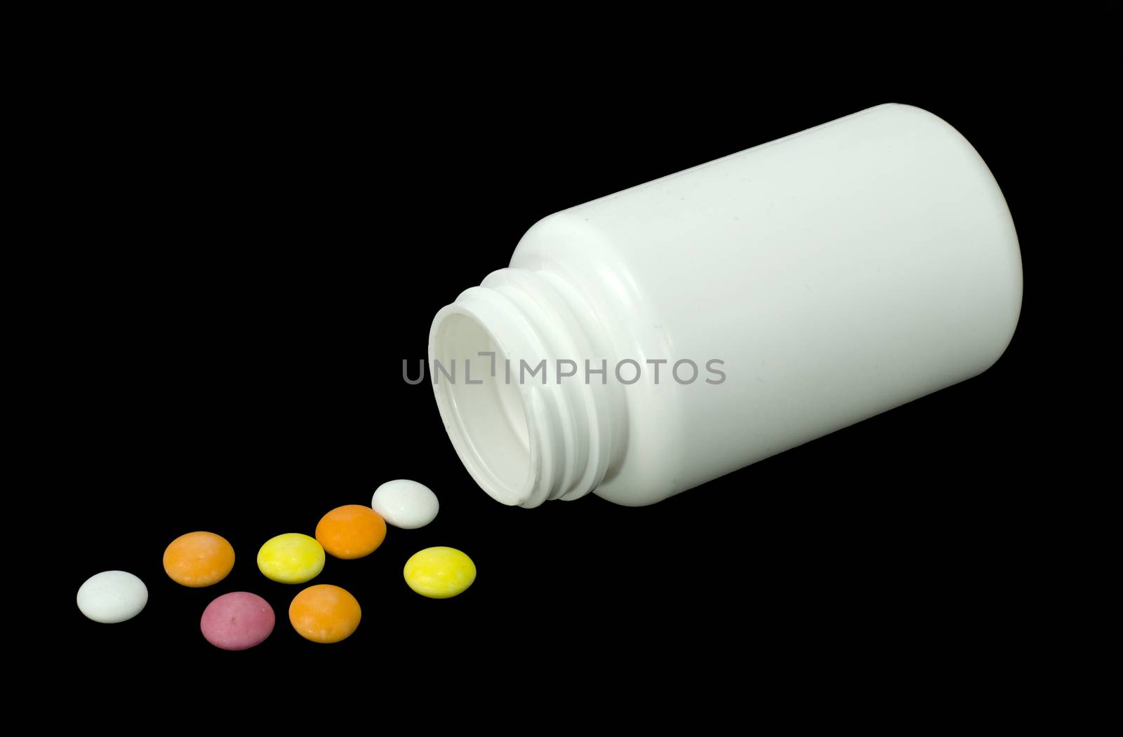 some pills of a different colors with white jar on a black background