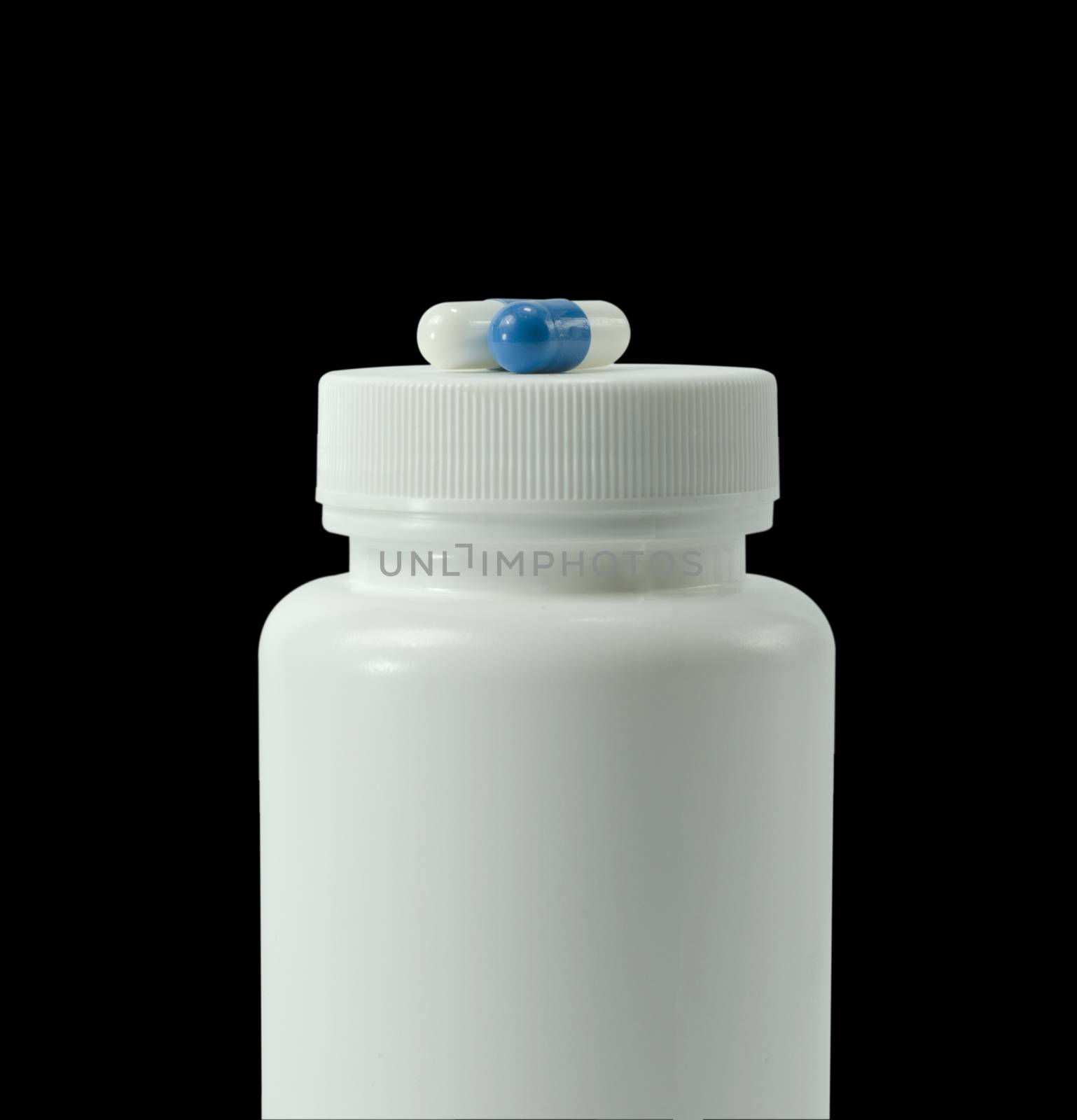 two pills of a white and blue colors with white jar on a black background