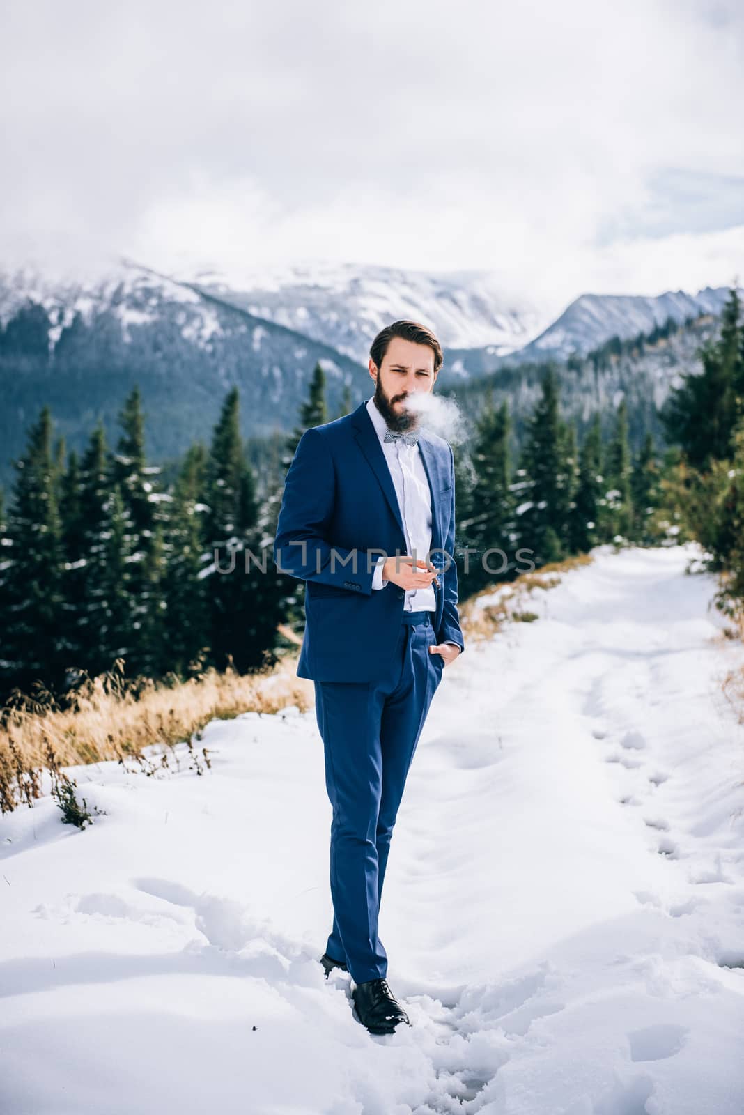 groom in a blue suit in the mountains Carpathians by Andreua