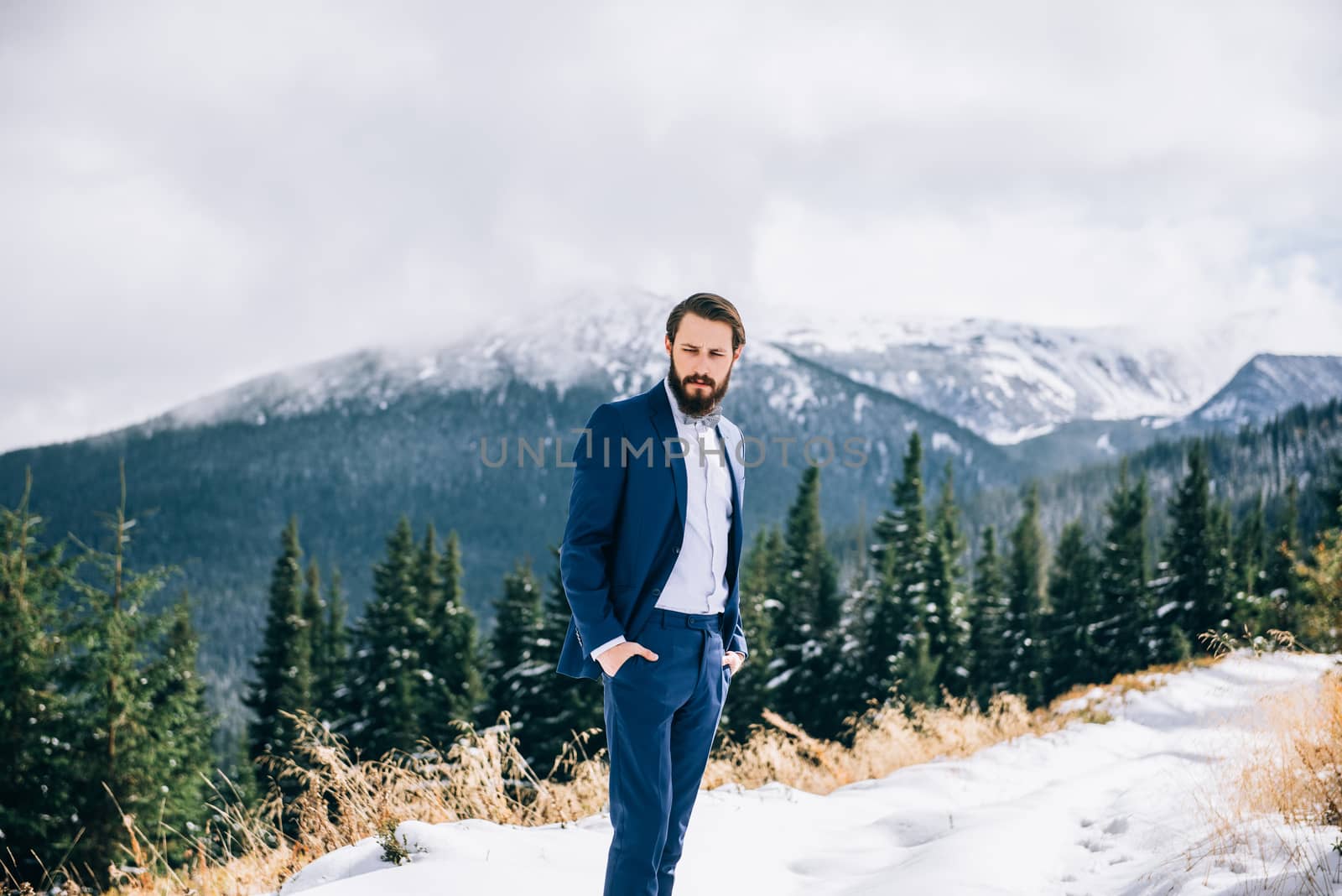groom in a blue suit in the mountains Carpathians by Andreua