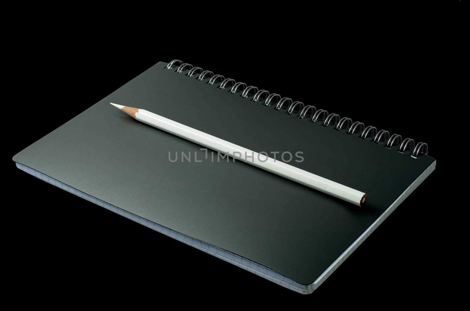 open notebook with pencil on a black background