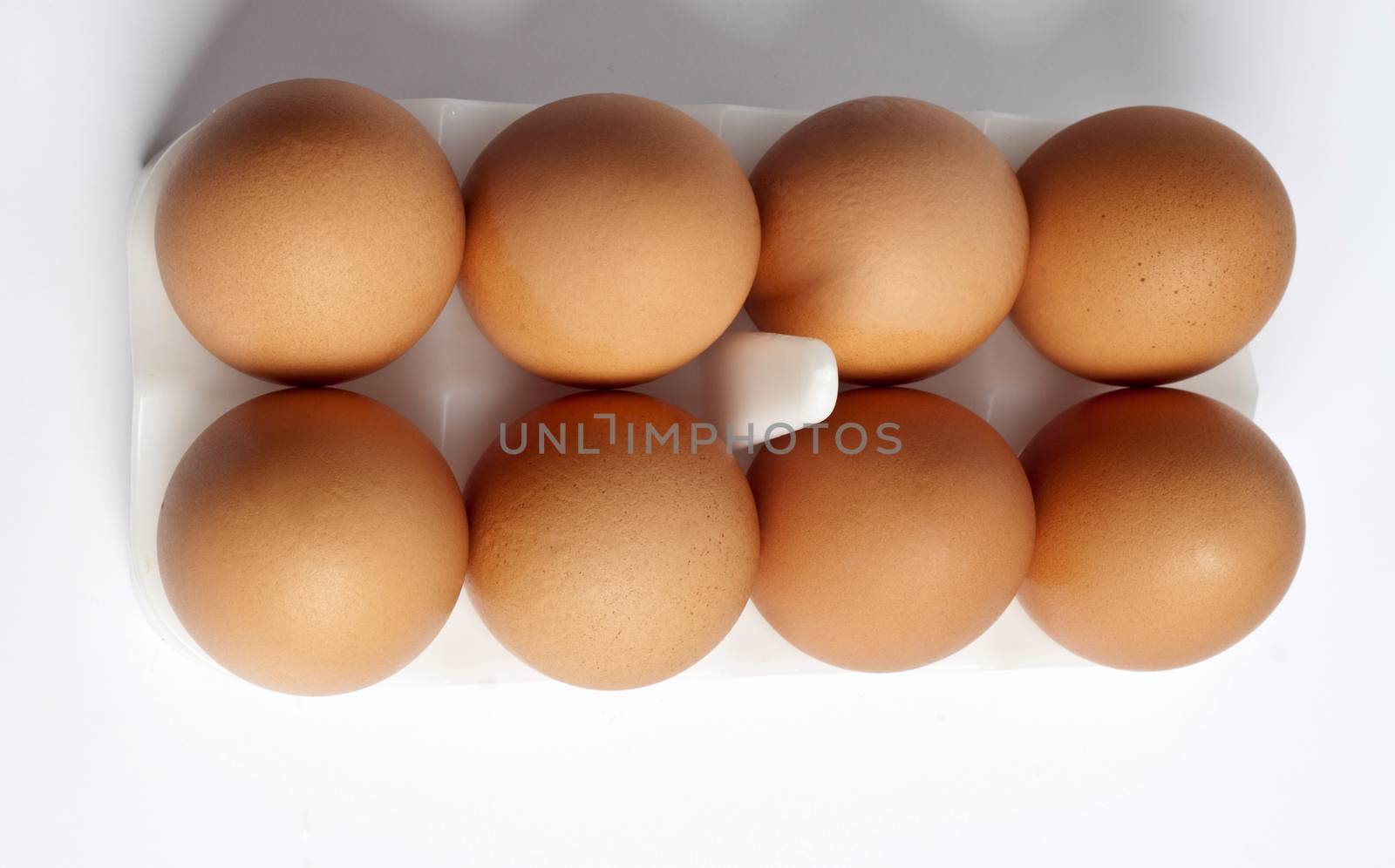 8 eggs in a box on a light background