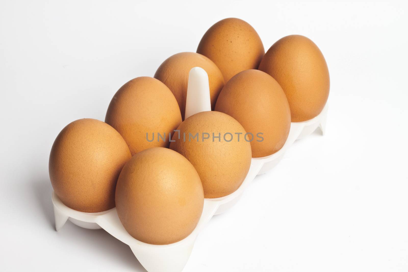 8 eggs in a box on a light background