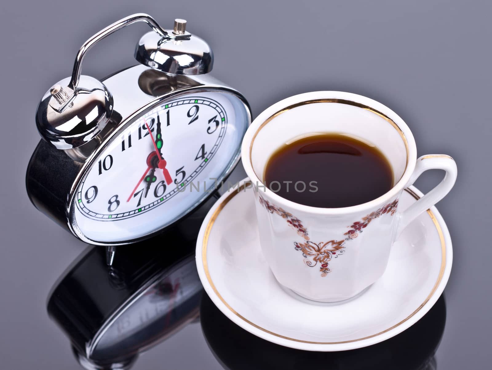 cup of coffee and watch the table on a dark background