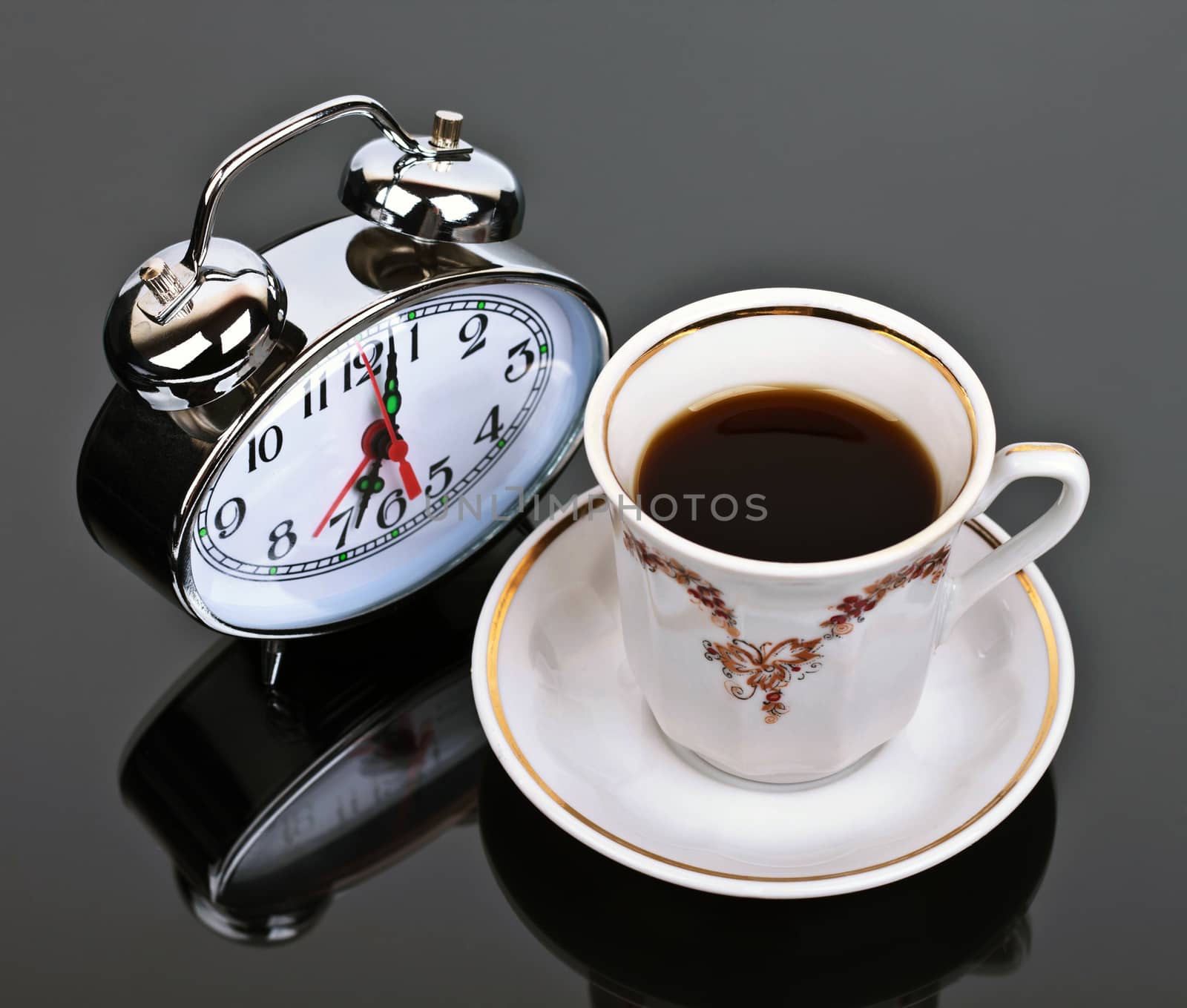 cup of coffee and watch the table on a dark background