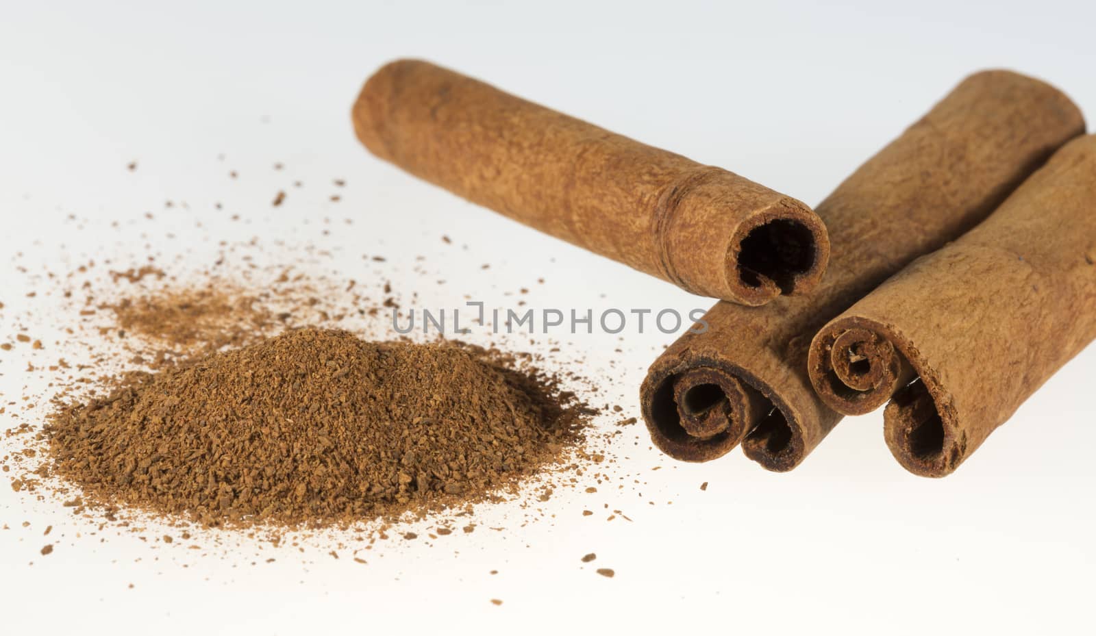 Cinnamon Sticks and Powder close up on white background.