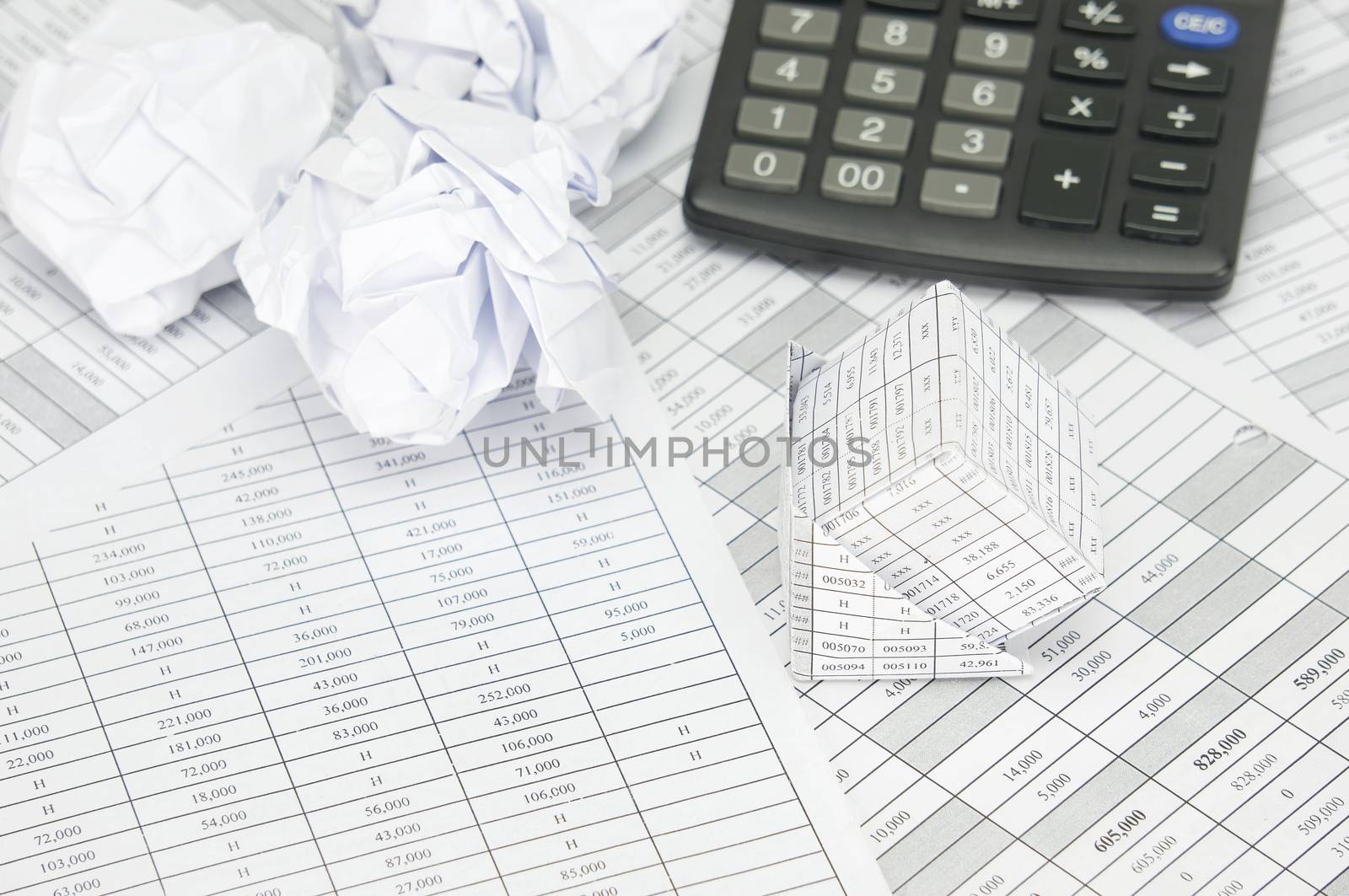 Bankruptcy of house and paper ball with calculator on finance account as background.