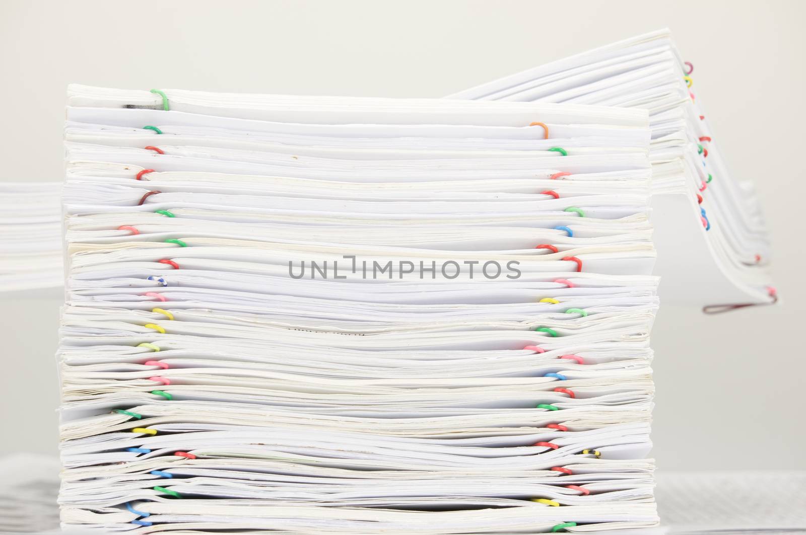 Pile of document with colorful paper clip on finance account place on white table.