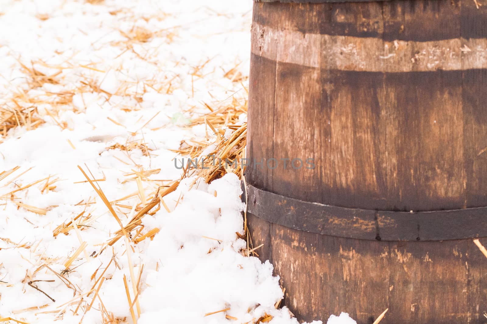 wooden barrel near the straw on the snow