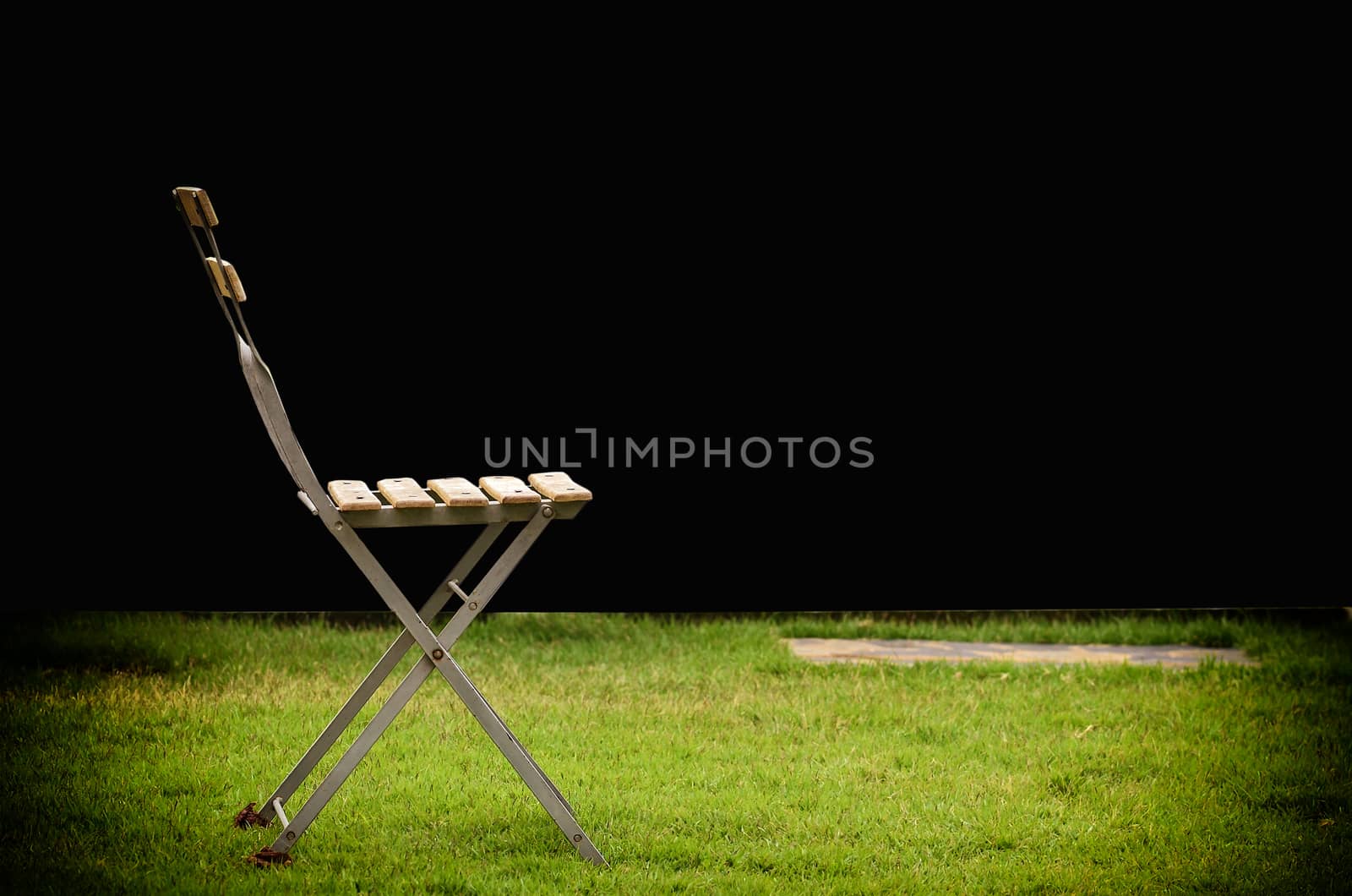 Old chair on green grass by raweenuttapong