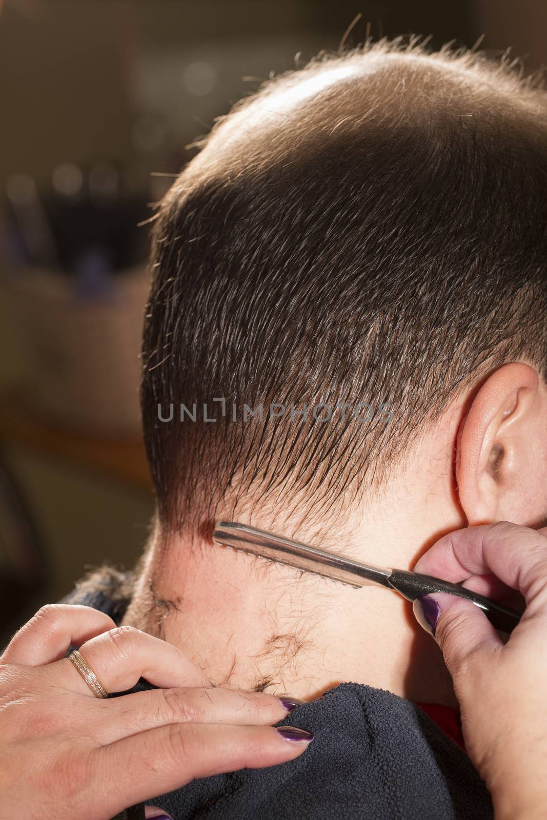 Hairdresser shaving near bald man by CatherineL-Prod