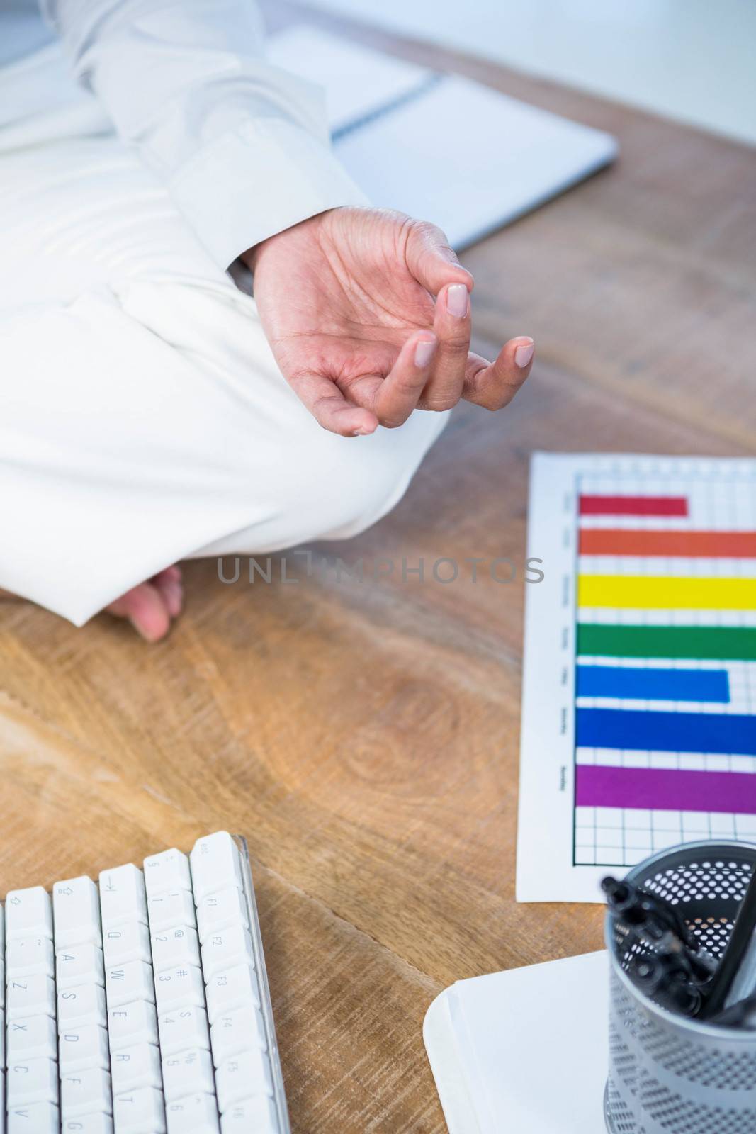 Close up of businesswoman doing yoga on floor by Wavebreakmedia