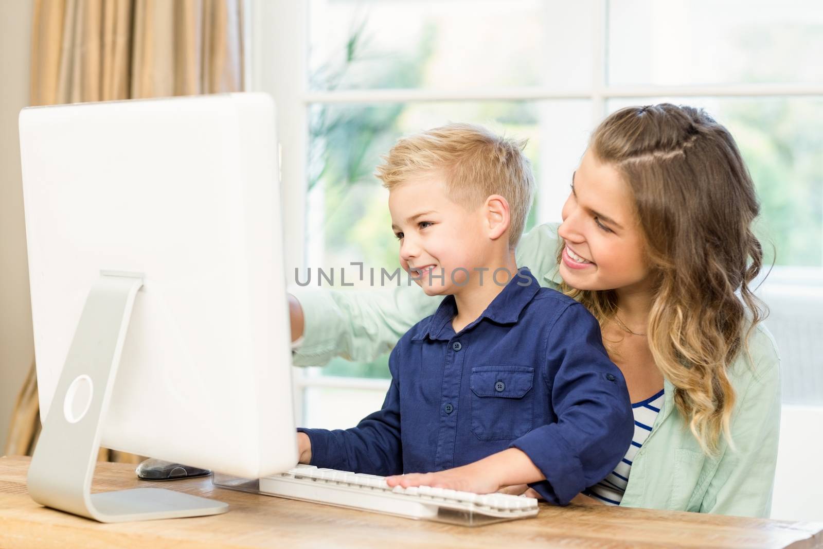 Mother and son using the computer at home