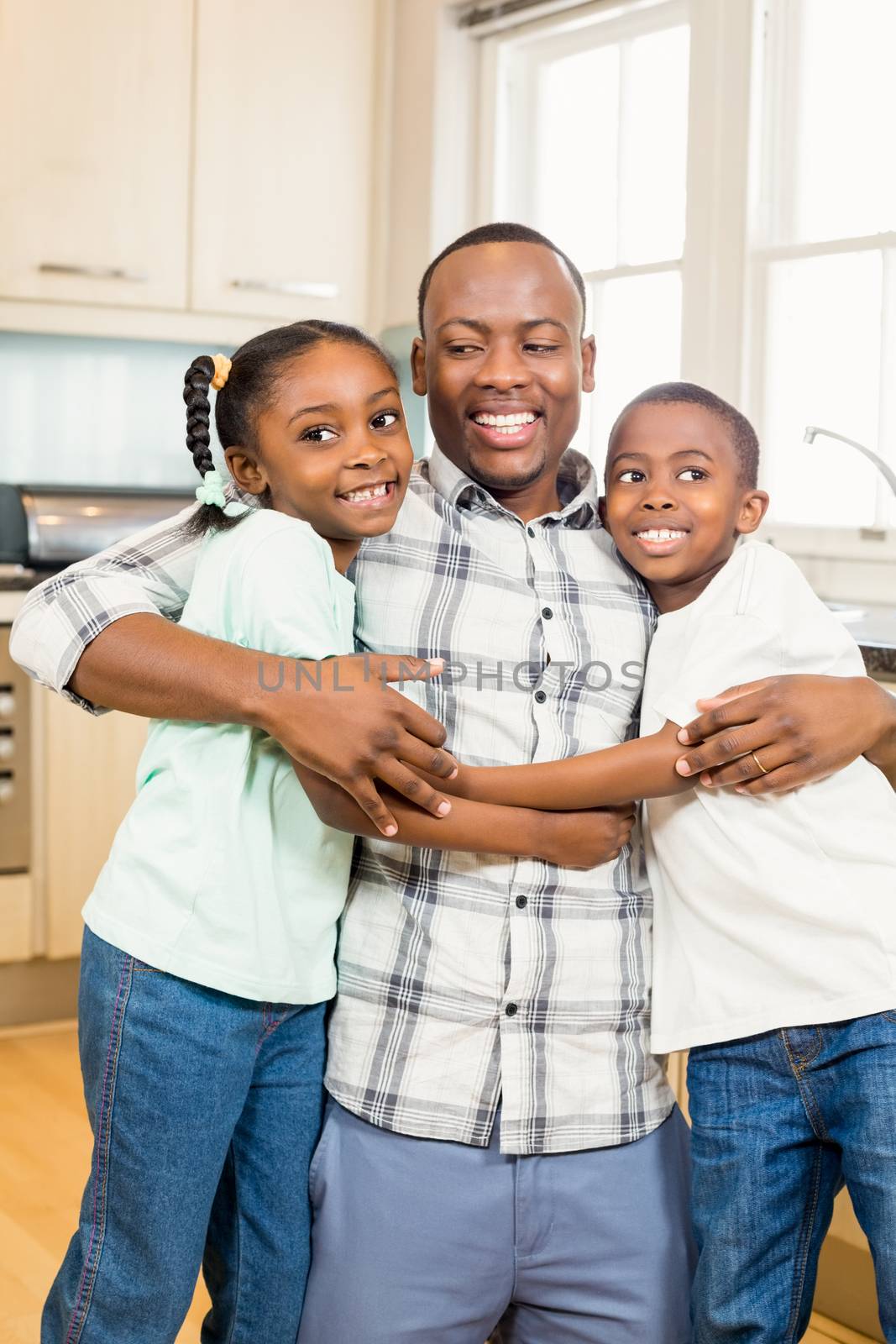 Happy family hugging in the kitchen  by Wavebreakmedia