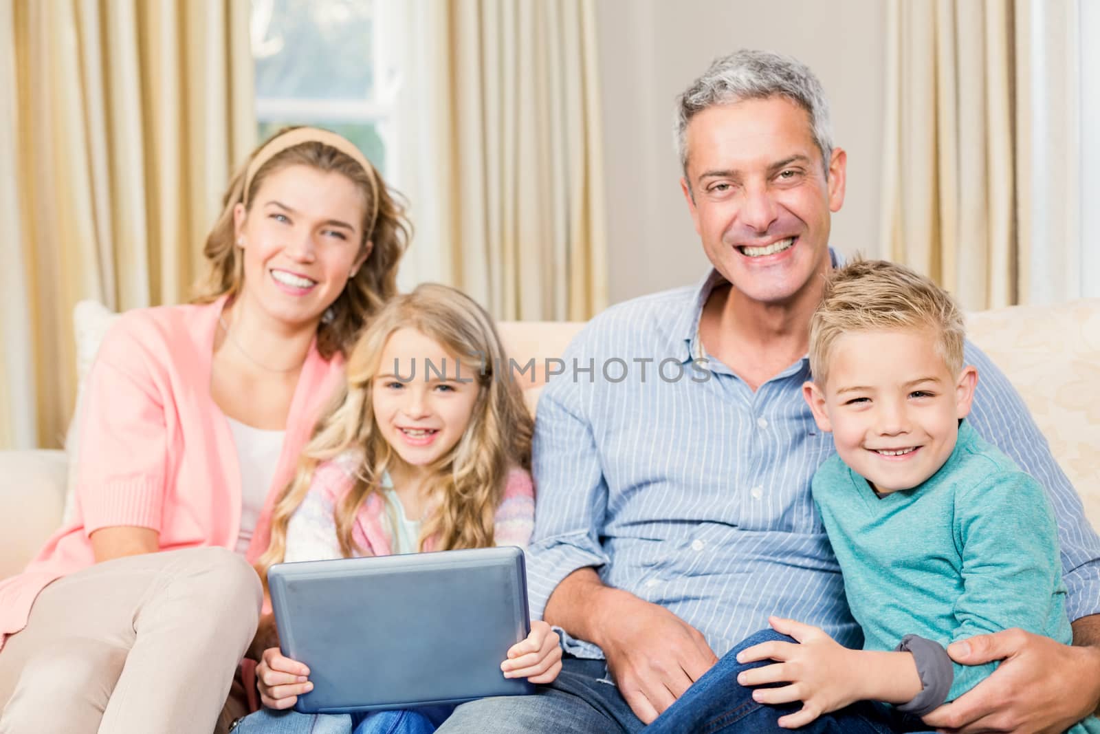 Happy family using tablet on the sofa in the living room