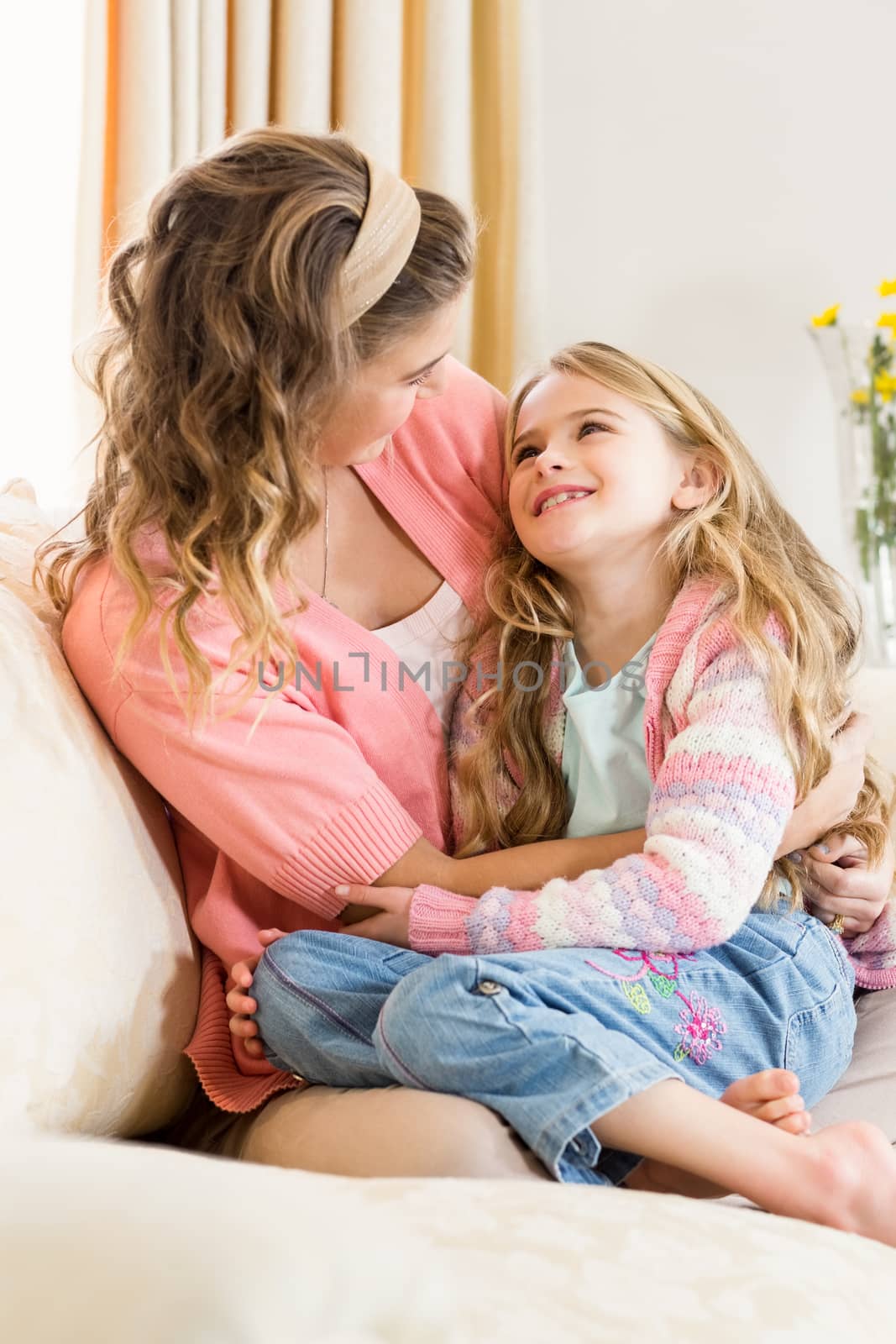 Mother and daughter smiling together on the couch