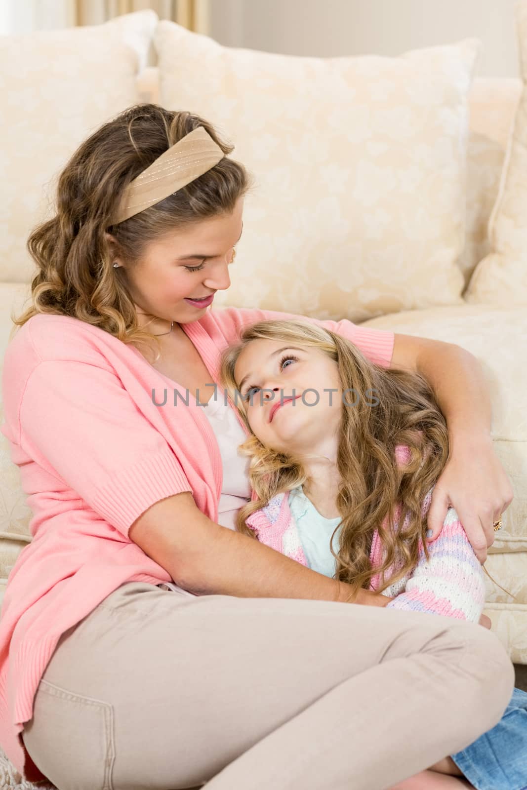 Mother and daughter smiling together by the couch