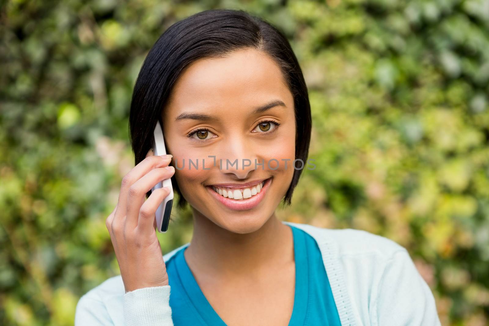 Smiling brunette on a phone call outdoors