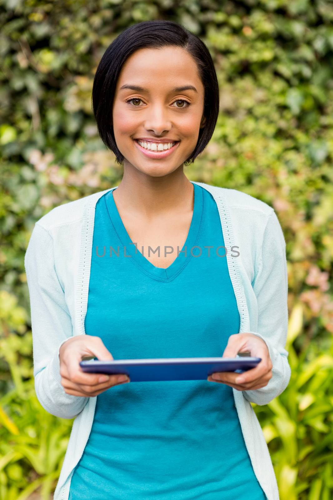 Smiling brunette using tablet by Wavebreakmedia