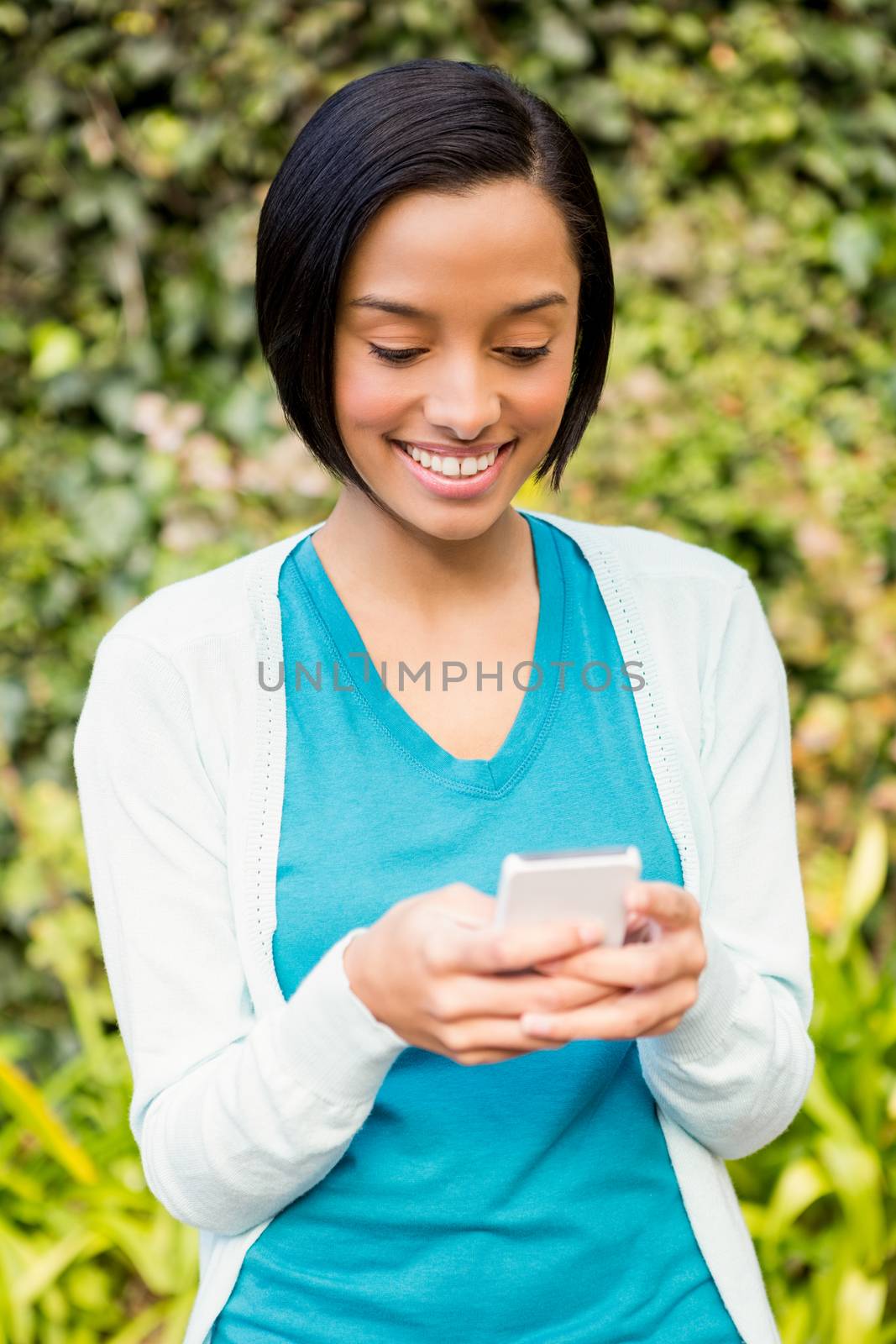 Attractive brunette using smartphone outdoors