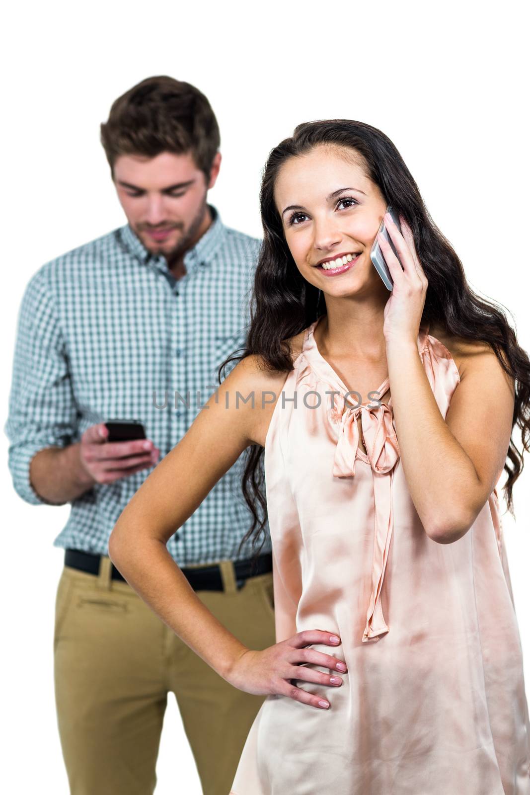 Smiling couple using smartphones by Wavebreakmedia