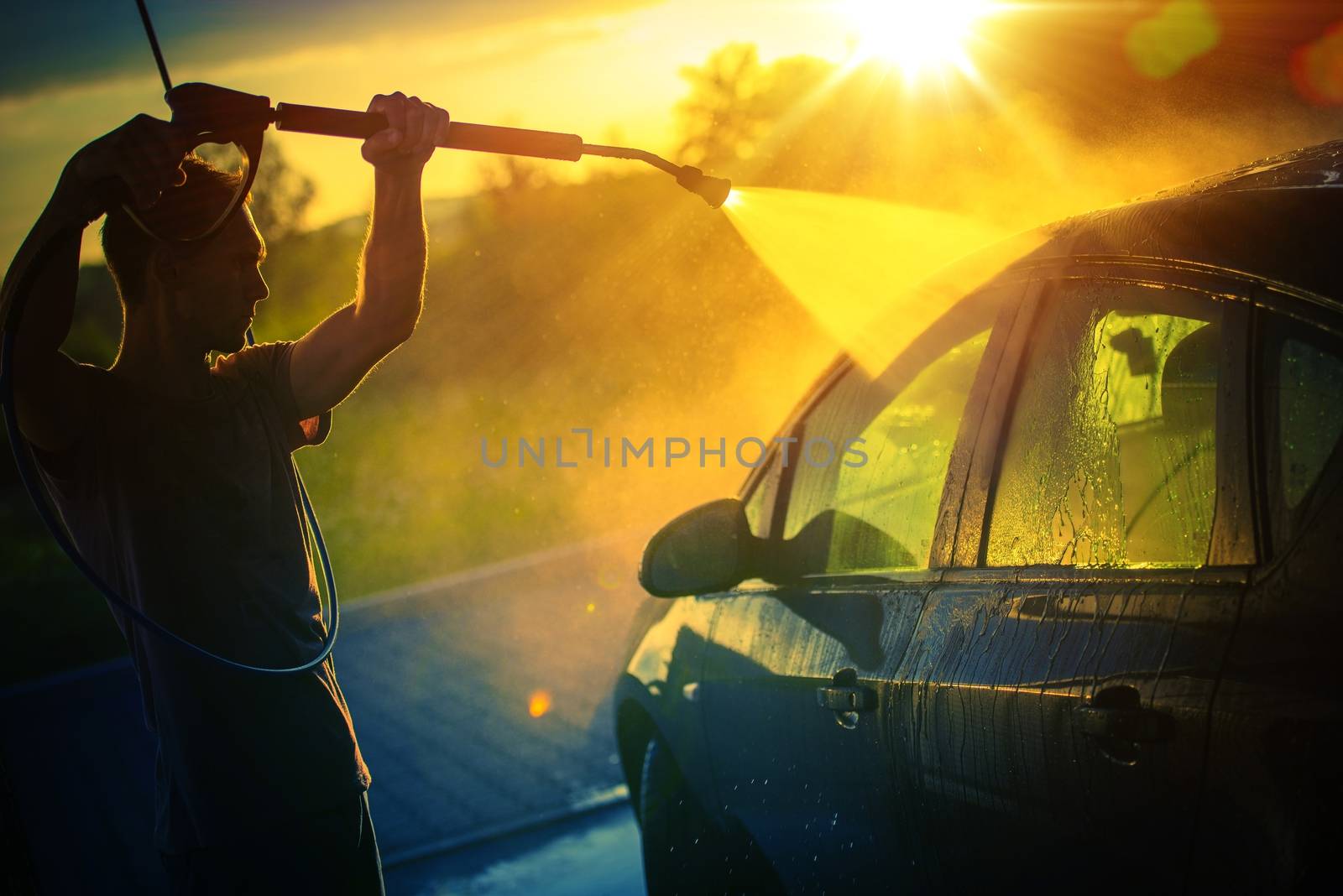 Vehicle Washing at Sunset, Hot Summer Afternoon Car Washing. High Pressure Water Washing.