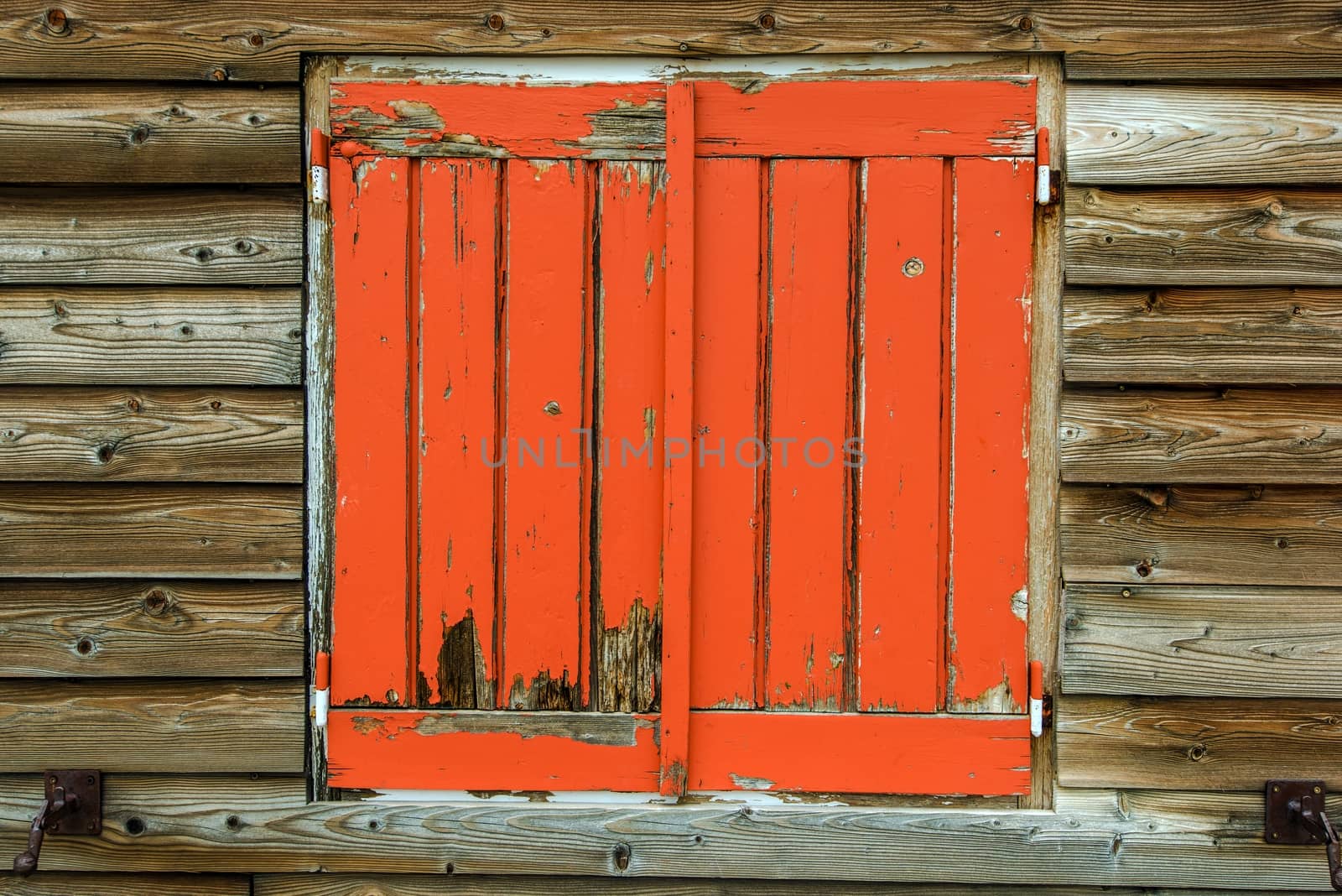 Old Orange Painted Wooden Window Covers in Rustic Wooden Cabin.