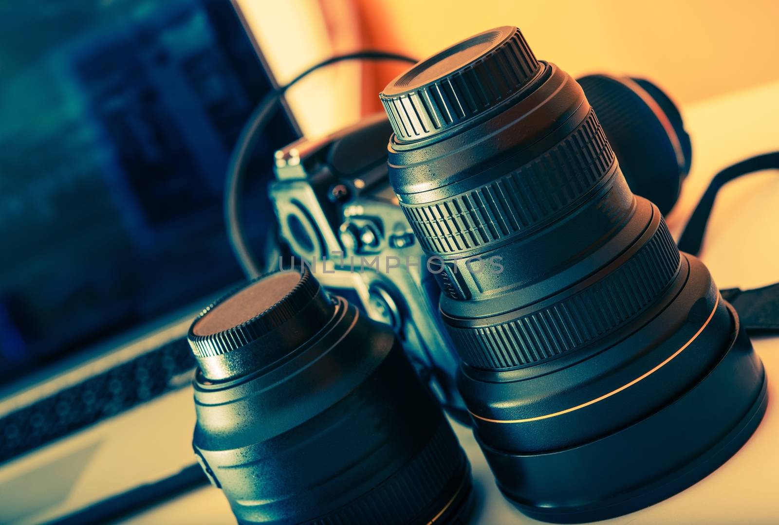Professional Digital Photograpy Equipment on a Desk. Photography Lenses, Digital Camera and Laptop Computer.