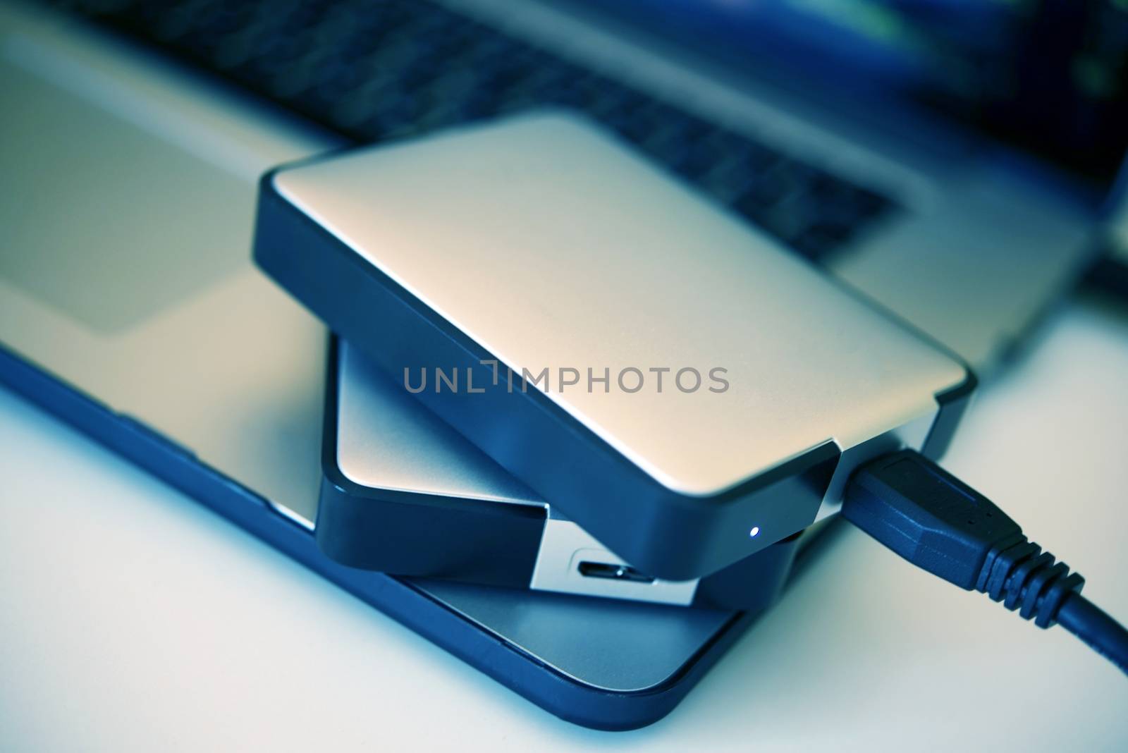 Portable Hard Drives Backup System. Two Portable Hard Drives on the Laptop Closeup Photo.