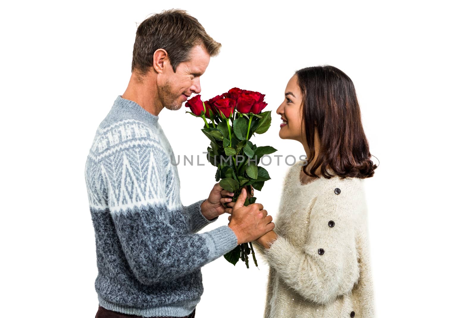 Romantic couple holding red roses against white background